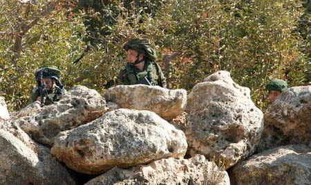 Israeli soldiers take position in the Israeli town of Metulla, as seen from the border village of Kfar Kila, south Lebanon October 26, 2016. REUTERS/Aziz Taher