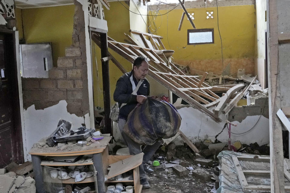 A man salvages usable items from his house badly damaged during Monday's earthquake in Cianjur, West Java, Indonesia, Wednesday, Nov. 23, 2022. The earthquake killed a number of people and left hundreds injured and missing on Indonesia's main island. (AP Photo/Tatan Syuflana)