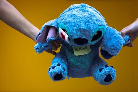 Secondary school students hold a Stitch plush toy with an eye patch as they form a human chain during a demonstration in Hong Kong