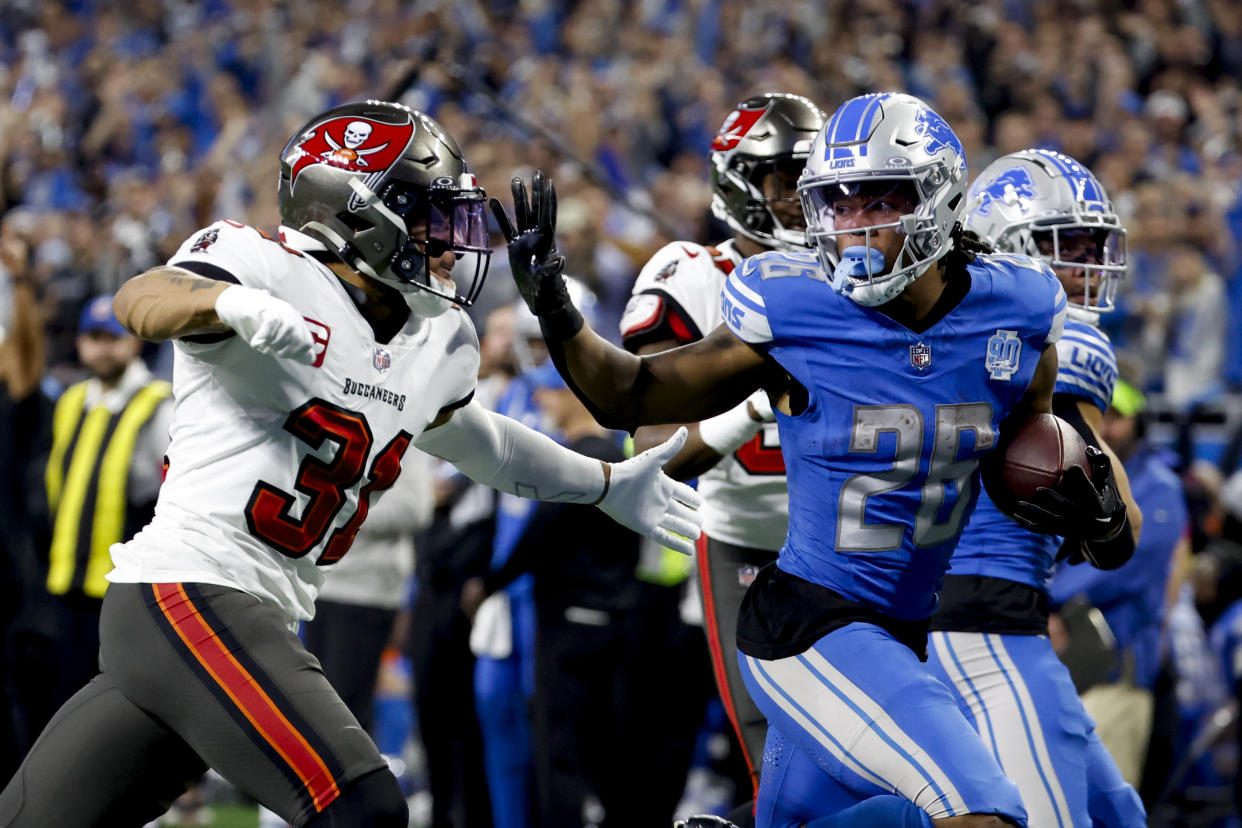 Detroit Lions running back Jahmyr Gibbs (26) rushes for a touchdown chased by Tampa Bay Buccaneers safety Antoine Winfield Jr. (31) in the second half during an NFL divisional round playoff football game Sunday, Jan. 21, 2024, in Detroit. (AP Photo/Rick Osentoski)