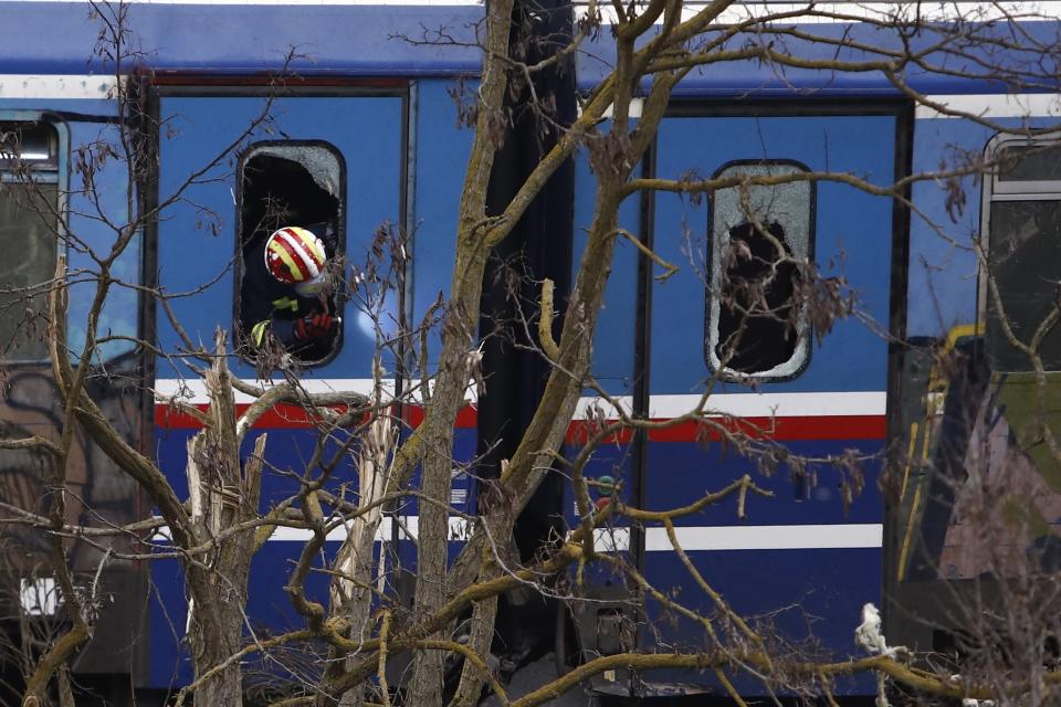 A firefighter searches inside a train after a collision in Tempe, about 376 kilometres (235 miles) north of Athens, near Larissa city, Greece, Wednesday, March 1, 2023. Rescuers searched Wednesday through the burned-out wreckage of two trains that slammed into each other in northern Greece, killing and injured dozens of passengers. (AP Photo/Giannis Papanikos)