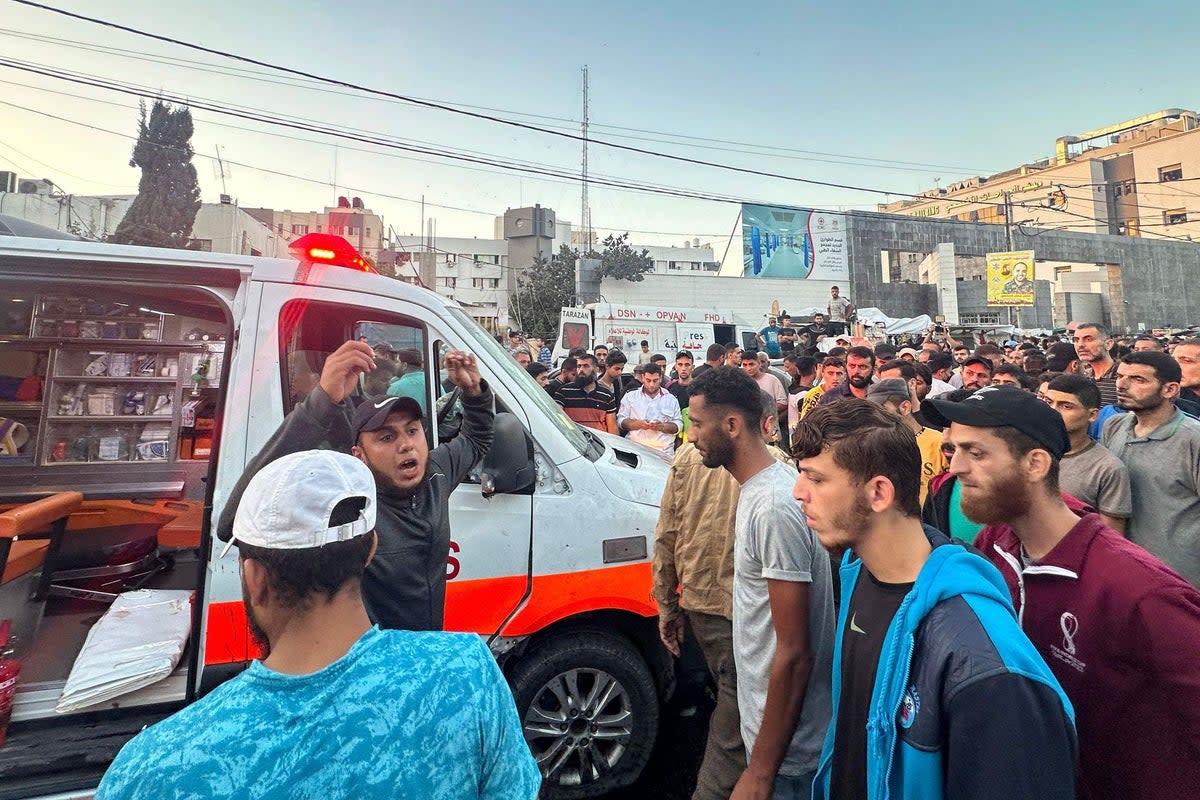 People gather around an ambulance damaged in a reported Israeli strike in front of Al-Shifa hospital in Gaza City on November 3 (AFP via Getty Images)