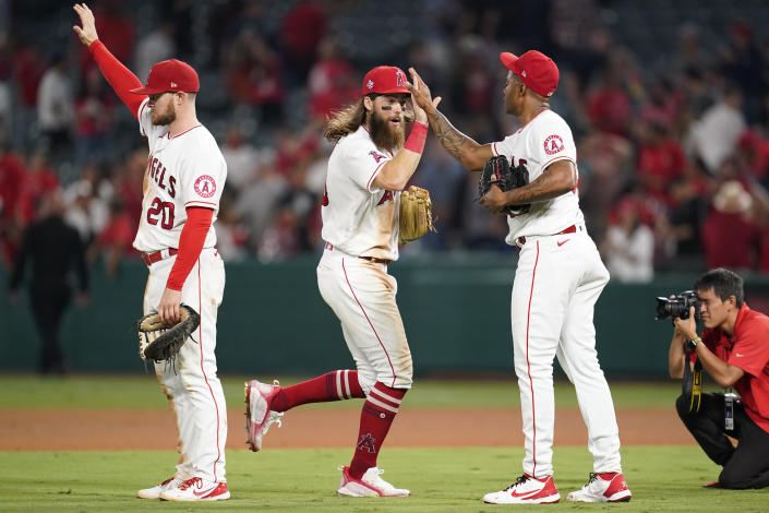 From left, Los Angeles Angels first baseman Jared Walsh (20), center fielder Brandon Marsh, and relief pitcher Raisel Iglesias celebrate after a 3-2 win over the Texas Rangers in a baseball game Friday, Sept. 3, 2021, in Anaheim, Calif. (AP Photo/Ashley Landis)