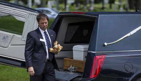 Glueckert Funeral Home Funeral Director John Glueckert carries a teddy bear for an abandoned baby boy during a burial service at All Saints Cemetery in Des Plaines, Illinois, June 19, 2015. REUTERS/Jim Young