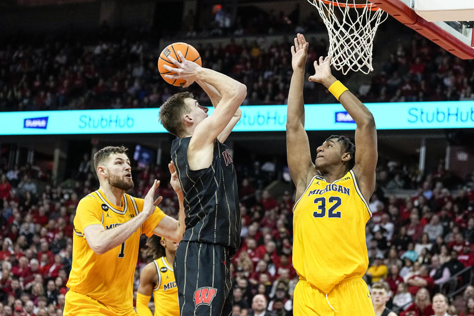 Wisconsin's Tyler Wahl (5) shoots against Michigan's Hunter Dickinson (1) and Tarris Reed (32) during the second half of an NCAA college basketball game Tuesday, Feb. 14, 2023, in Madison, Wis. (AP Photo/Andy Manis)