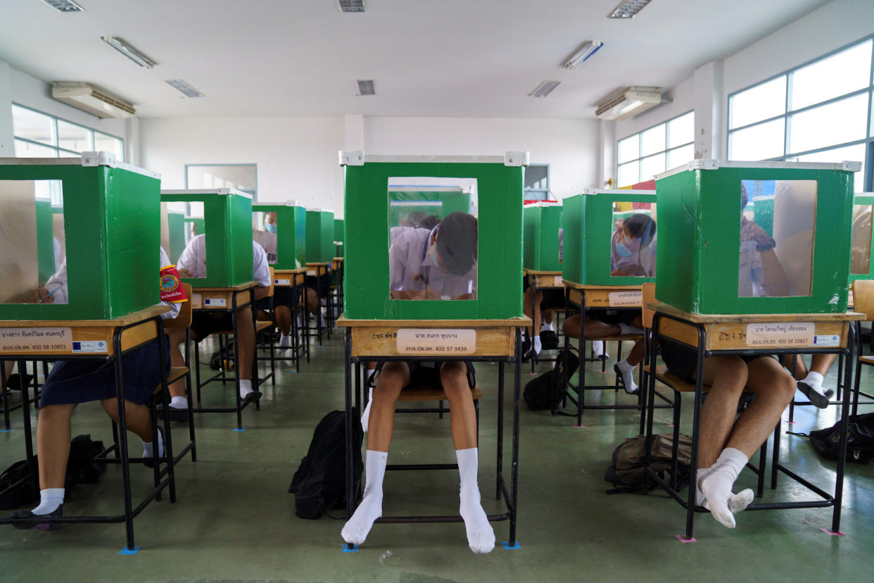 Students wearing face masks and face shields are seen inside old ballot boxes repurposed into partitions as they attend class at Sam Khok School in the province of Pathum Thani, Thailand, on July 1. (Photo: Athit Perawongmetha/Reuters)