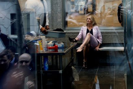 Adult-film actress Stephanie Clifford, also known as Stormy Daniels, puts her shoe back on after passing though a security screening, as she arrives at federal court in the Manhattan borough of New York City, New York, U.S., April 16, 2018. REUTERS/Shannon Stapleton