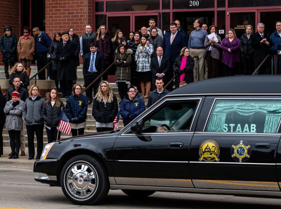 People gather on the steps of the Sangamon County Building to pay their respects as the procession for Frank and Cinda Edwards passes by as they go through downtown en route to Oak Ridge Cemetery, Tuesday, Feb. 4, 2020, in Springfield, Ill. [Justin L. Fowler/The State Journal-Register] 