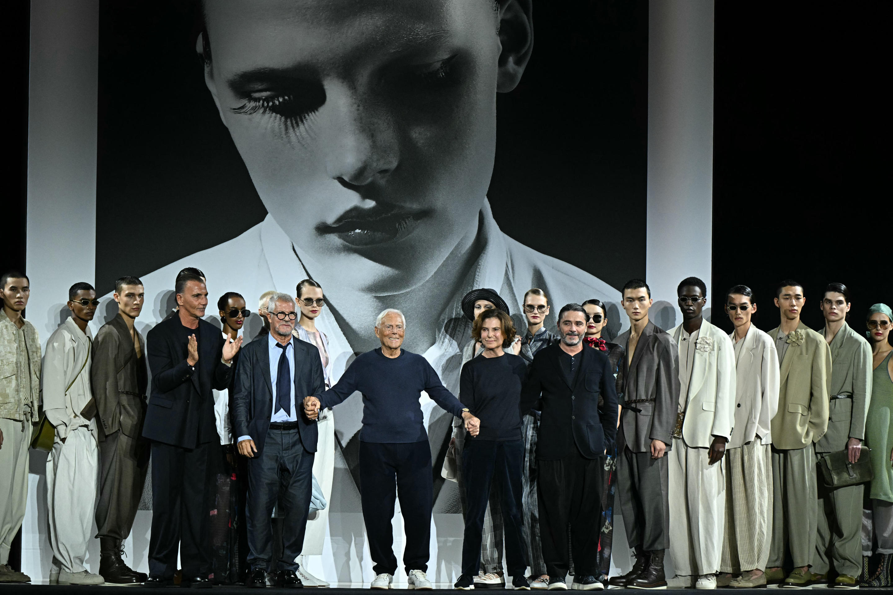 Italian designer Giorgio Armani, center,  stands on the runway at the end of the Emporio Armani collection show.