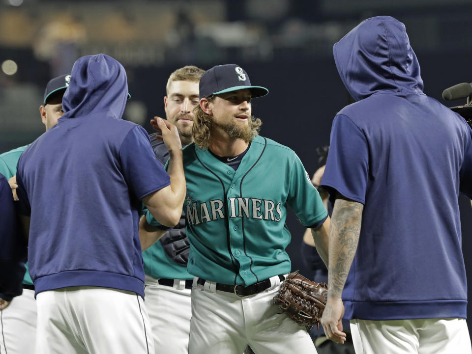 Seattle Mariners starting pitcher Mike Leake, center, is greeted by teammates after he threw a one-hitter against the Los Angeles Angels in a baseball game Friday, July 19, 2019, in Seattle. The Mariners won 10-0. (AP Photo/Ted S. Warren)