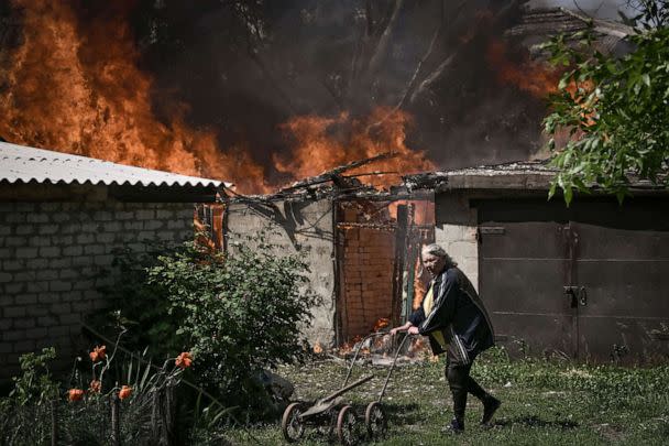 PHOTO: An elderly woman walks away from a burning house in Lysytsansk, a city located in the eastern Ukrainian region of Donbas, on May 30, 2022. (AFP Contributor via Getty Images)