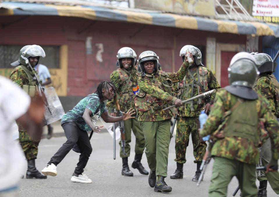 Police clash with a man during a protest by supporters of Kenya's opposition leader Raila Odinga over the high cost of living and alleged stolen presidential vote, in Nairobi, Monday, March 20, 2023. (AP Photo/Brian Inganga)