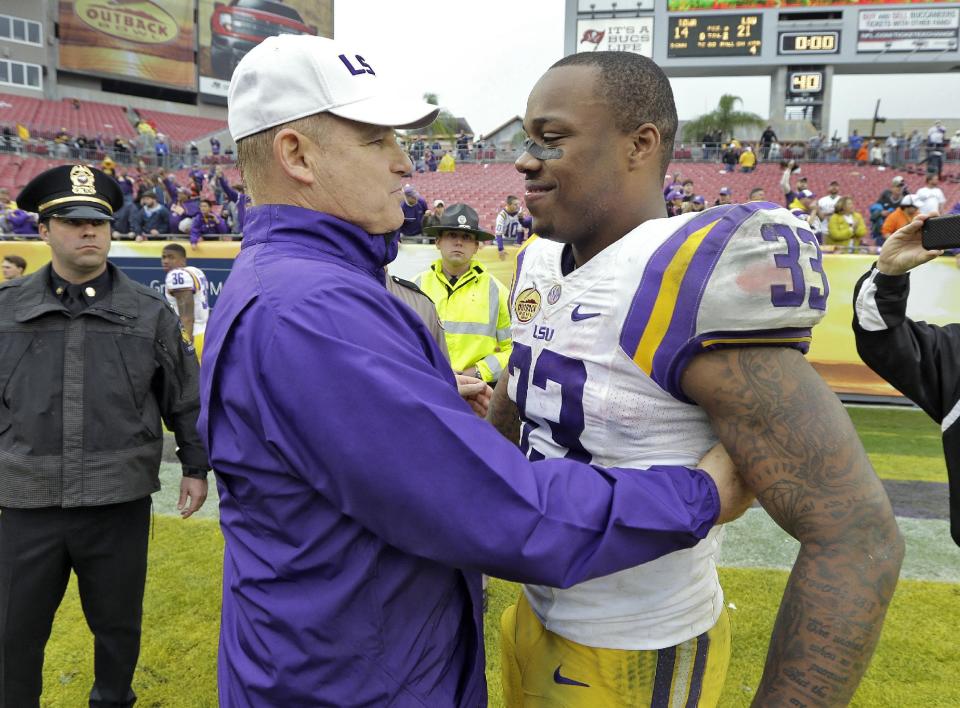 LSU head coach Les Miles, left, congratulates MVP Jeremy Hill (33) after LSU defeated Iowa 21-14 during the Outback Bowl NCAA college football game Wednesday, Jan. 1, 2014, in Tampa, Fla. (AP Photo/Chris O'Meara)
