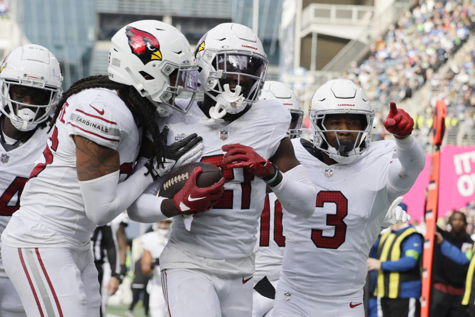 Arizona Cardinals cornerback Garrett Williams, center, celebrates his interception against the Seattle Seahawks with Cardinals safeties Budda Baker (3) and Andre Chachere, left, during the second half of an NFL football game Sunday, Oct. 22, 2023, in Seattle. (AP Photo/John Froschauer)