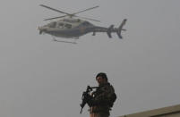 A police helicopter flies over as a member of police special forces stands guard during the first hearing of the trial for Turkish soldiers accused of attempting to assassinate Turkish President Tayyip Erdogan on the night of the failed last year's July 15 coup, in Mugla, Turkey, February 20, 2017. REUTERS/Kenan Gurbuz