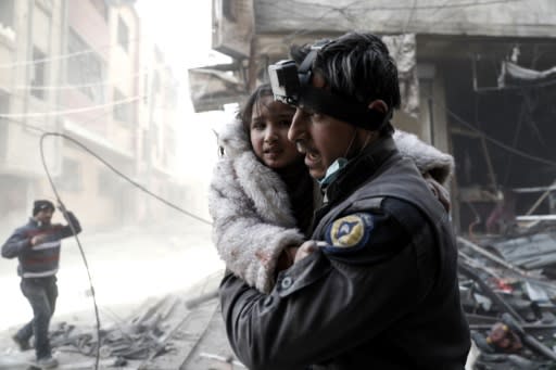 A Syrian White Helmets rescue worker carries a girl from the site of a government airstrike on the rebel-held town of Douma, on the eastern outskirts of Damascus, on February 25, 2017