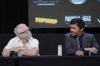 Manny Pacquiao, right, of the Philippines, looks at his trainer Freddie Roach during a news conference Wednesday, Aug. 18, 2021, in Las Vegas. Pacquiao is scheduled to fight Yordenis Ugas, of Cuba, in a welterweight championship bout Saturday in Las Vegas. (AP Photo/John Locher)