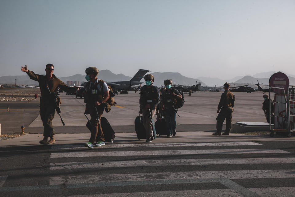 A Marine assigned to the 24th Marine Expeditionary Unit (MEU) escorts Department of State personnel to be processed for evacuation at Hamid Karzai International Airport, in Kabul, Afghanistan, Sunday, Aug. 15, 2021. (Sgt. Isaiah Campbell/U.S. Marine Corps via AP)