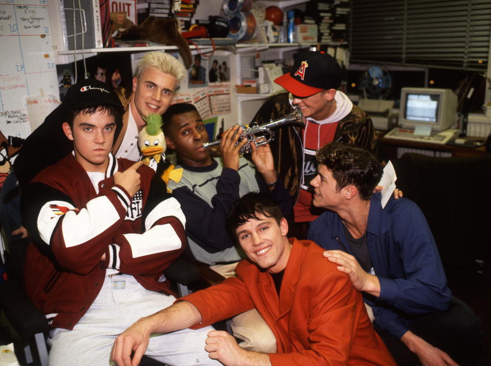 Robbie Williams, Jason Orange, Howard Donald, Mark Owen and Gary Barlow of English pop group Take That pose with television presenter Andi Peters and Edd the Duck, circa 1994.  (Photo by Tim Roney/Getty Images)