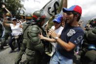 Anti-government protesters scuffle with national guards as they march by Generalisimo Francisco de Miranda Airbase in Caracas March 4, 2014. Venezuela geared up on Tuesday for commemorations of socialist leader Hugo Chavez's death despite continued protests against his successor that have shaken the OPEC member and threatened the legacy of "El Comandante." REUTERS/Tomas Bravo