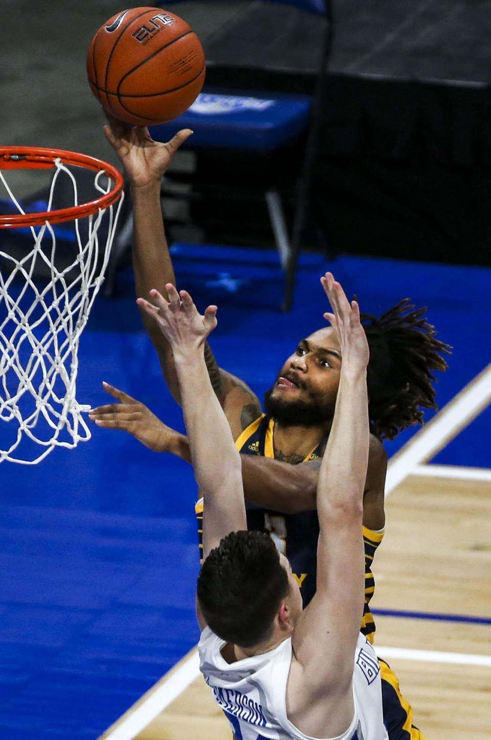 FILE - UMKC guard Brandon McKissic (3) makes a layup over Saint Louis guard Gibson Jimerson (24) during the first half of an NCAA college basketball game in St. Louis, in this Wednesday, Dec. 23, 2020, file photo. Florida added three defensive stalwarts via the NCAA transfer portal, led by two-time Big South defensive player of the year Phlandrous Fleming and Summit League defensive player of the year Brandon McKissic, to bolster a lineup the Gators believe will be able to compete in the stacked Southeastern Conference. (Colter Peterson/St. Louis Post-Dispatch via AP)