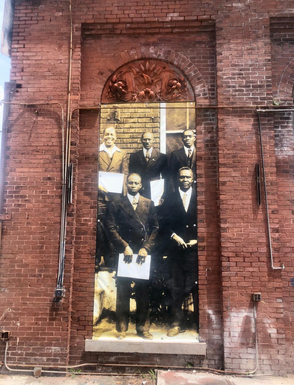 A historic picture hangs on the side of the Water Works building near the Enmarket Arena in west Savannah.