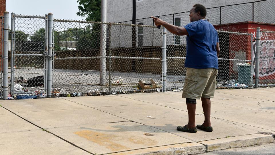 Lifelong Camden resident Christoff Lindsey reminisces in front a vacant school in his neighborhood where Lindsey once played basketball in the schoolyard.  The vacant school is now littered with items such as spent syringes and human waste.