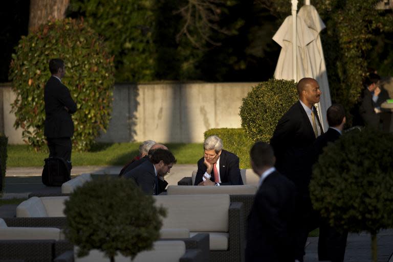 US Secretary of State John Kerry (R-seated) talks with members of his delegation after a meeting with Iranian Foreign Minister Javad Zarif and other officials at the Beau Rivage Palace Hotel, March 27, 2015, in Lausanne, Switzerland