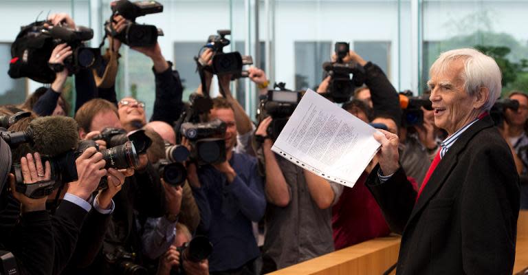 German Green party parliamentarian Hans-Christian Stroebele holds up a letter as he arrives to address a press conference in Berlin on November 1, 2013