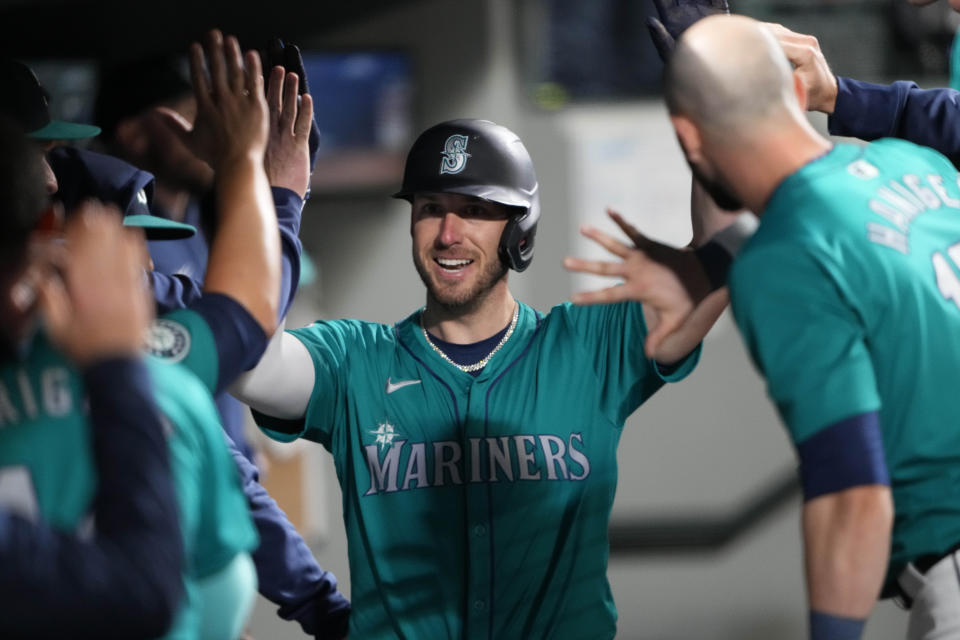 Seattle Mariners' Mitch Garver is greeted in the dugout after scoring on an RBI single by Luke Raley against the Arizona Diamondbacks during the fifth inning of a baseball game Saturday, April 27, 2024, in Seattle. (AP Photo/Lindsey Wasson)