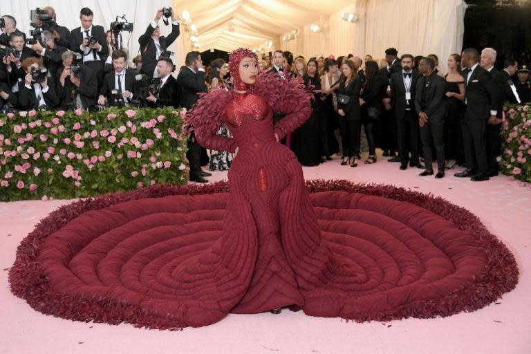 Cardi B attended the 2019 Met Gala wearing a show-stopping red gown that took more than 2,000 hours to create.Last year, the rapper arrived at the event – which carried the theme "Heavenly Bodies: Fashion and the Catholic Imagination" – wearing a gem-encrusted gown that showed off her baby bump.This year however, the singer opted for a more reserved, yet equally dramatic ensemble. On Monday night, the Bodak Yellow singer wore a floor-length oxblood custom Thom Browne gown that featured a mammoth train made up of concentric circles that spanned around ten feet. In fact, the train was so big, that Cardi B had to be accompanied by a team of five men as she made her way up The Metropolitan Museum of Art’s grand staircase. According to Vogue, the dress was made from tulle and silk organza and was filled with down.It was also decorated with 30,000 burnt and dyed coque feathers, and took 35 people more than 2,000 hours to make. Cardi B completed her Met Gala look with a bugle-bead headpiece that was designed by Browne in collaboration with British milliner Stephen Jones. Speaking to Vogue, Browne said that the dress was inspired by the female form. “I designed this dress for Cardi specifically because she has the ultimate beauty in a woman’s body, and that is what the dress is about for me: taking advantage of that beauty,” the designer told the publication.The rapper’s dress gained a lot of attention on social media where she was praised for “slaying” the red carpet. “Cardi B never disappoints,” one person wrote.> Can you say jaw-dropping? @iamcardib takes flight as she arrives at the MetGala. MetCamp CardiB pic.twitter.com/alZDlJbud7> > — The Met (@metmuseum) > > May 7, 2019Another added: “Cardi b always slays met gala I do have to give her that.”A third person commented: “Cardi B dress looks comfy af, I wanna lay on it so bad [sic].”> Was just shaken to the ground by the ultimate duvet dress @iamcardib metgala pic.twitter.com/SDKmVnxTOr> > — Man Repeller (@ManRepeller) > > May 7, 2019Keep up to date with The Independent's Met Gala 2019 coverage here.
