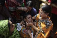 Women help a relative of a garment worker, who went missing in the Rana Plaza collapse, after she fainted on the first year anniversary of the accident, as people gather in Savar April 24, 2014. Protesters and family members of victims demand compensation on the one year anniversary of the collapse of Rana Plaza, in which more than 1,100 factory workers were killed and 2,500 others were injured.