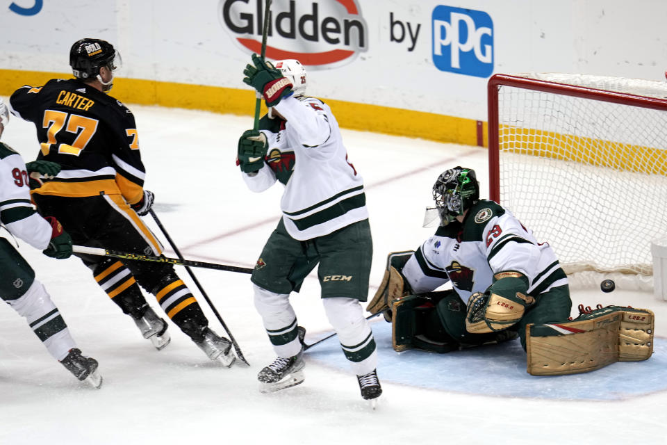 Pittsburgh Penguins' Jeff Carter (77) shoots behind Minnesota Wild goaltender Marc-Andre Fleury (29) for a goal with Wild's Jonas Brodin, center, defending during the third period of an NHL hockey game in Pittsburgh, Thursday, April 6, 2023. (AP Photo/Gene J. Puskar)