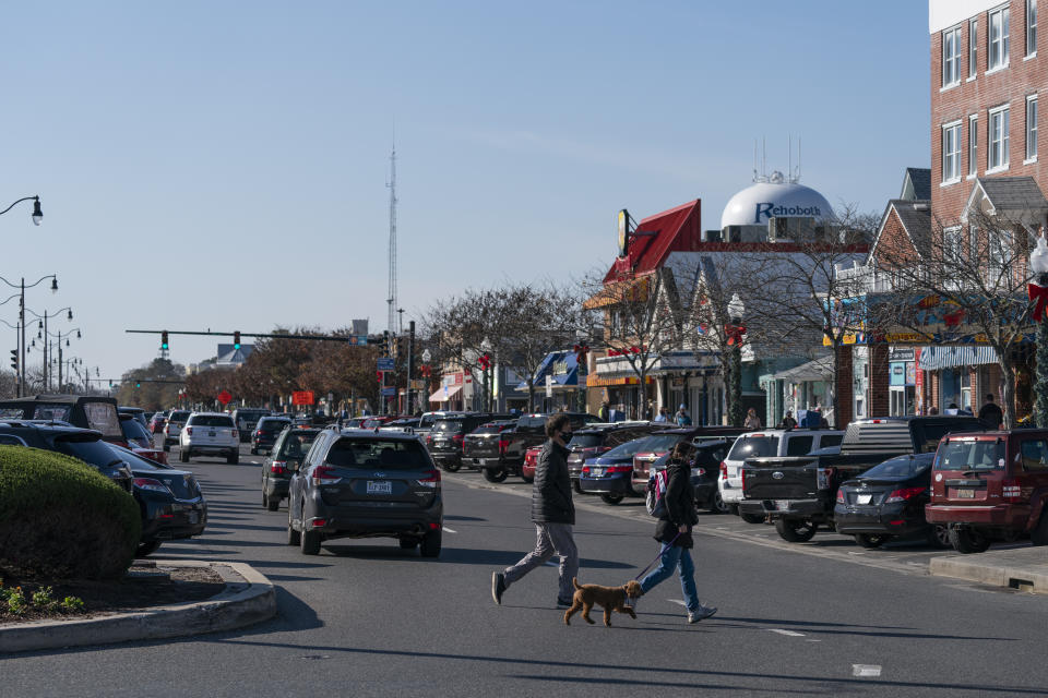 People cross the Rehoboth Avenue, Friday, Nov. 13, 2020, in Rehoboth Beach, Del. President-elect Joe Biden owns a $2.7 million, Delaware North Shores home with a swimming pool that overlooks Cape Henlopen State Park, is blocks from the ocean and a short drive from downtown Rehoboth Beach.(AP Photo/Alex Brandon)