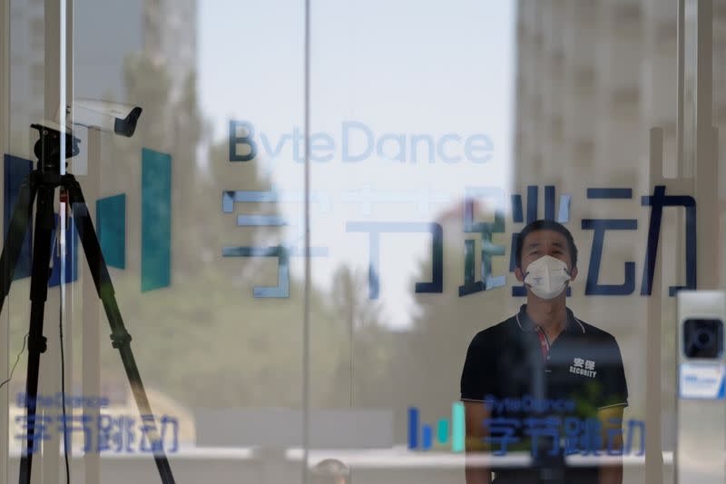 FILE PHOTO: Security guard stands near a surveillance camera at an office of Bytedance, which owns short video app TikTok, in Beijing