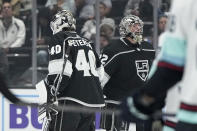 Los Angeles Kings goaltender Cal Petersen, left, and goaltender Jonathan Quick pass each other as the Kings switch goalies during the second period of an NHL hockey game against the Seattle Kraken Tuesday, Nov. 29, 2022, in Los Angeles. (AP Photo/Mark J. Terrill)