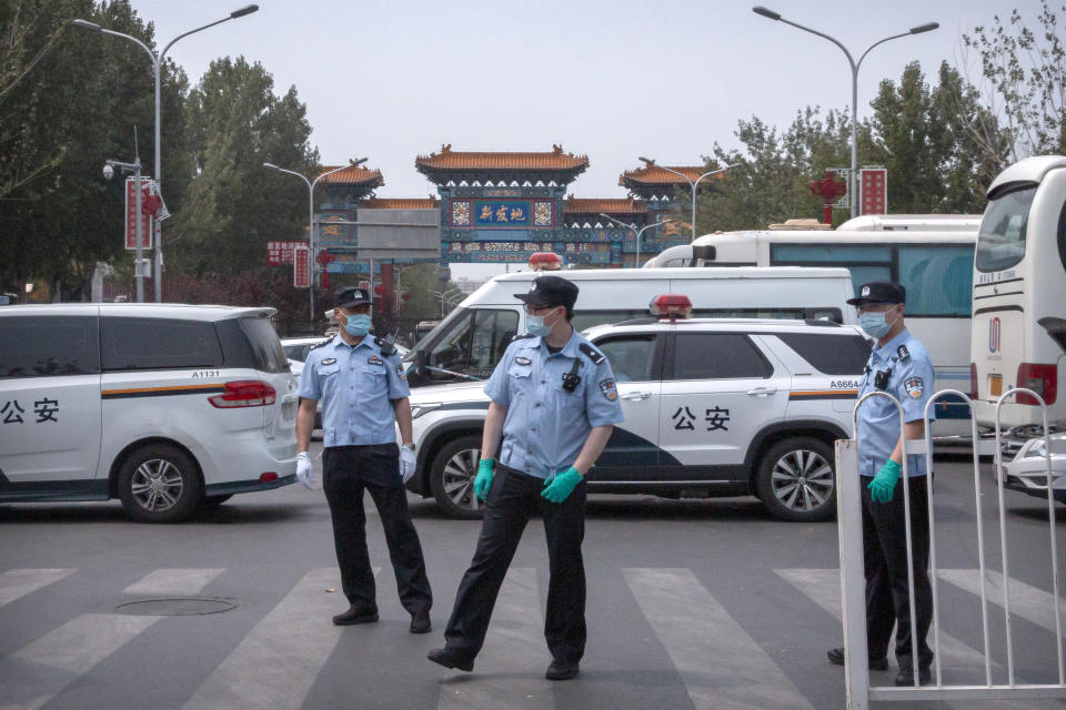 Chinese police stand guard outside an entrance to the Xinfadi wholesale food market district in Beijing, Saturday, June 13, 2020. Beijing closed the city's largest wholesale food market Saturday after the discovery of seven cases of the new coronavirus in the previous two days. (AP Photo/Mark Schiefelbein)