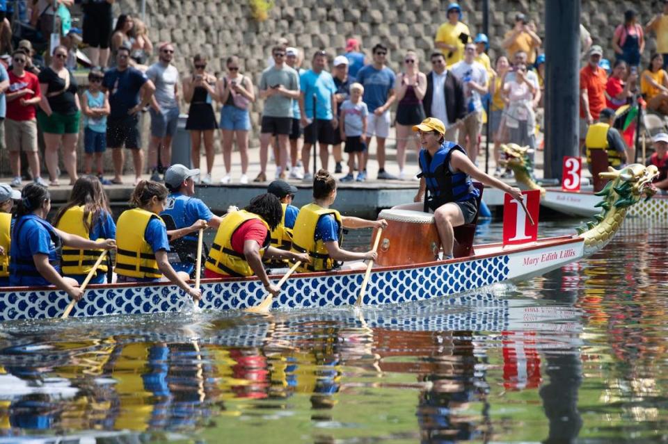 Spectators line the pier to cheer for teams competing in the dragon boat races at the 35th annual Kansas City Dragon Boat Festival on Saturday, along Bush Creek.