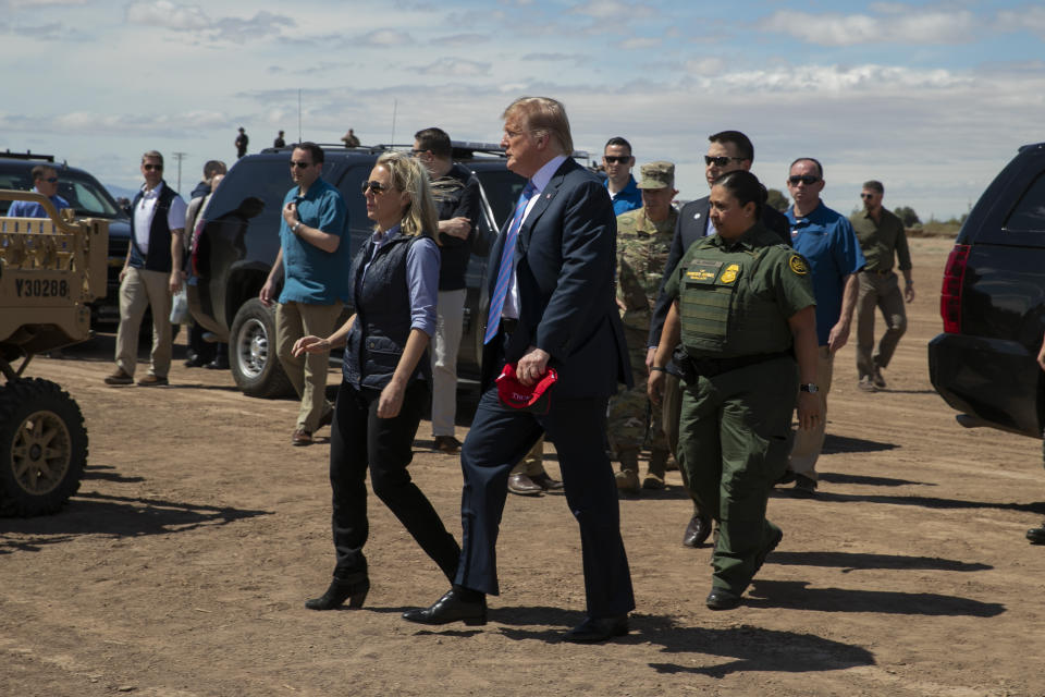 Donald Trump (centro) vista el muro fronterizo de Calexico, California, acompañado por la secretaria de Seguridad Nacional Kirstjen Nielsen el viernes 5 de abril del 2019. Horas después, Nielsen renunciaría en el marco de un replanteo de las políticas hacia la inmigración, que Trump se propone endurecer. (AP Photo/Jacquelyn Martin)