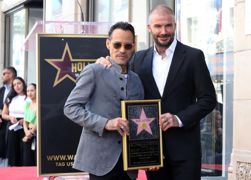 Marc Anthony y el invitado sorpresa David Beckham posan para fotografías mientras