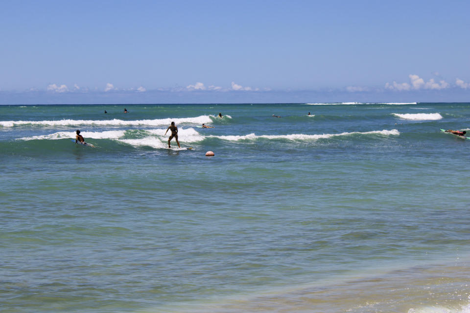 Surfers ride waves at a surf spot known as White Plains in Ewa Beach, Hawaii, on Friday, May 12, 2023. A prominent Hawaiian waterman wants to build another Hawaii wave pool facility using the latest technology to simulate the ideal conditions top-notch surfers need to stay competitive. But some people, including fellow Hawaiians, want to stop the project and say it's a waste of water and pointless when there are many nearby beaches for surfing. (AP Photo/Jennifer Sinco Kelleher)