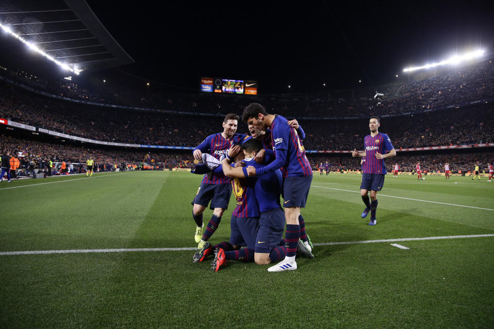 Barcelona players hug teammate Luis Suarez after he scores his side's first goal during a Spanish La Liga soccer match between FC Barcelona and Atletico Madrid at the Camp Nou stadium in Barcelona, Spain, Saturday April 6, 2019. (AP Photo/Manu Fernandez)