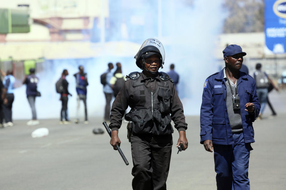 Riot police patrol the streets during protests in Harare, Friday, Aug, 16, 2019. Zimbabwe's police patrolled the streets of Harare Friday morning while many residents stayed home and shops were shut fearing violence from an anti-government demonstration. Zimbabwe's High Court has upheld the police ban on the opposition protest.(AP Photo/Tsvangirayi Mukwazhi)