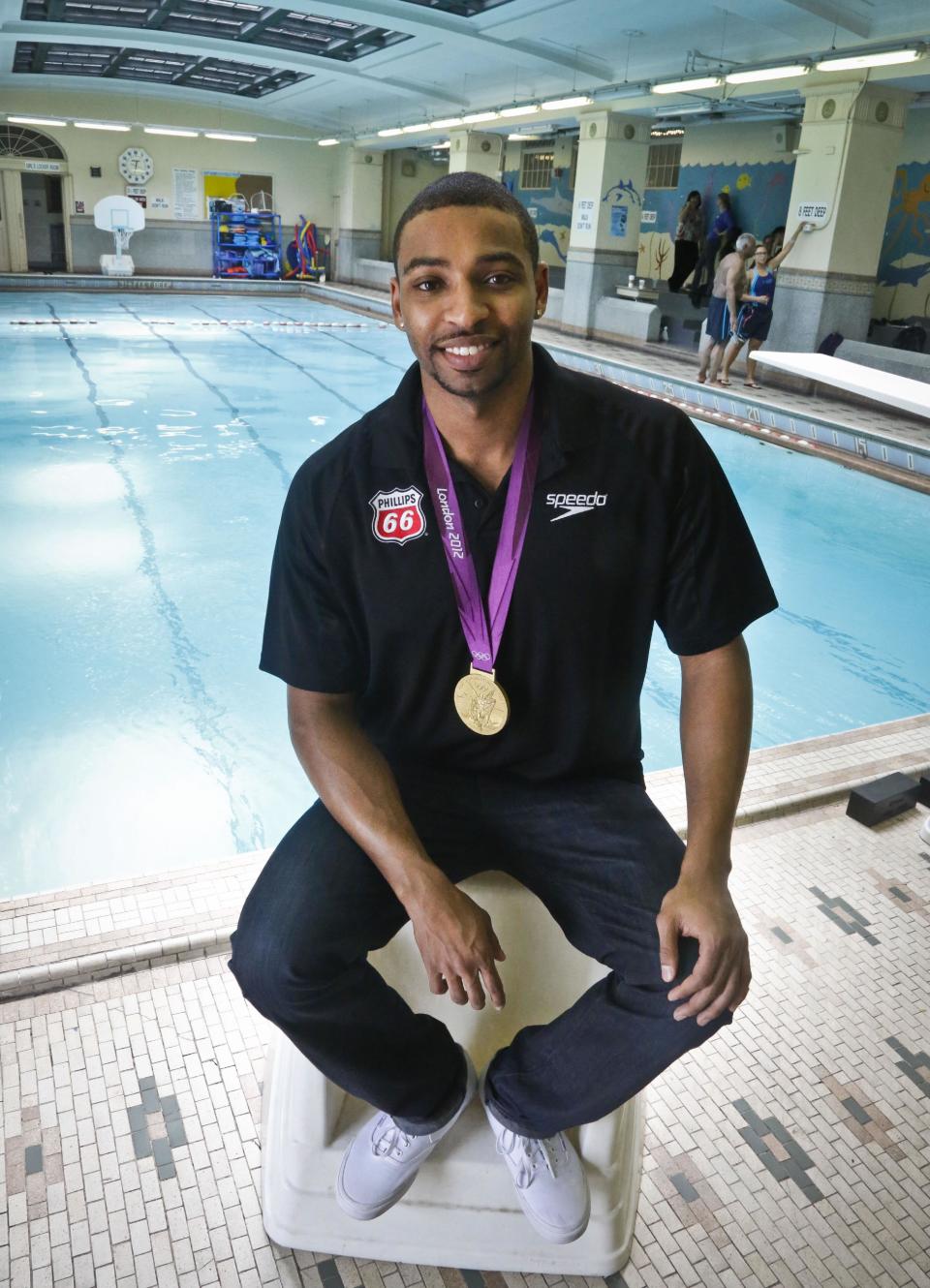 This May 17, 2013 photo shows Olympic gold medalist swimmer Cullen Jones posing poolside after giving swimming lesson's to students at Harlem's P.S. 125 in New York. Jones is ambassador for the 5th Annual USA Swimming Foundation's "Make a Splash Tour," a program to provide free swimming lessons, water safety education and awareness at city pools. (AP Photo/Bebeto Matthews)