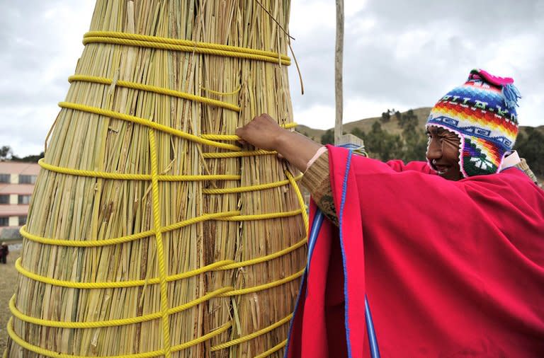 A man works on the construction of a reed boat or "Thunupa" on Suriqui island in Lake Titicaca, Bolivia, on December 2, 2012. Ships built of bullrush reed have sailed the Pacific, the Atlantic, the Mediterranean, and for a millennia across the Titicaca, the vast Andean lake 4,700 meters (15,420 feet) above the sea level shared by Bolivia and Peru