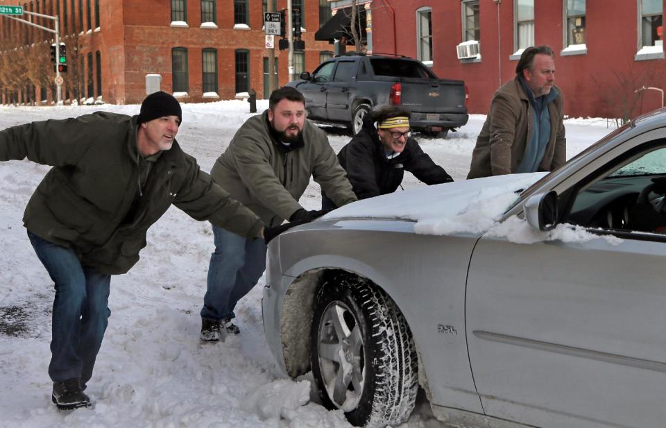 From left to right, Mark Panzeri, Cody Hudson, Dave Kaplan and Sam Bauer try to push stalled motorist James Harrison's car off an icy patch on Tuesday, Jan. 7, 2014, in Soulard, Mo. "I was on my way to work when I saw he was stalled. I went to get a shovel to help out," said Panzeri. The rest of the men joined in when they saw Panzeri needed the help. (AP Photo/St. Louis Post-Dispatch, Laurie Skrivan) EDWARDSVILLE INTELLIGENCER OUT; THE ALTON TELEGRAPH OUT