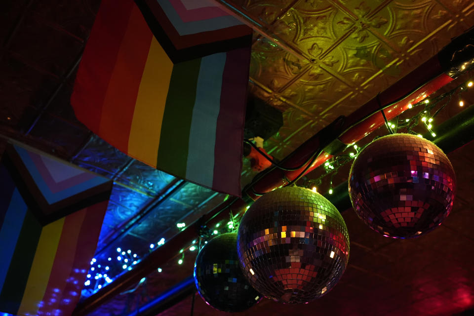 Decorations hang from the ceiling inside the Stonewall Inn, Monday, June 17, 2024 in New York. In 1969 Stonewall had the biggest bar and one of the two dance floors that drew its young, diverse crowd. But after a raid sparked an uprising and the Stonewall shut down, 51 Christopher St. became a bagel shop, a gay bar briefly again, a clothing store, a nail salon, then a vacant space. Its big “STONEWALL INN” sign came down in 1989, a few years before a new version of the tavern opened. (AP Photo/Pamela Smith)