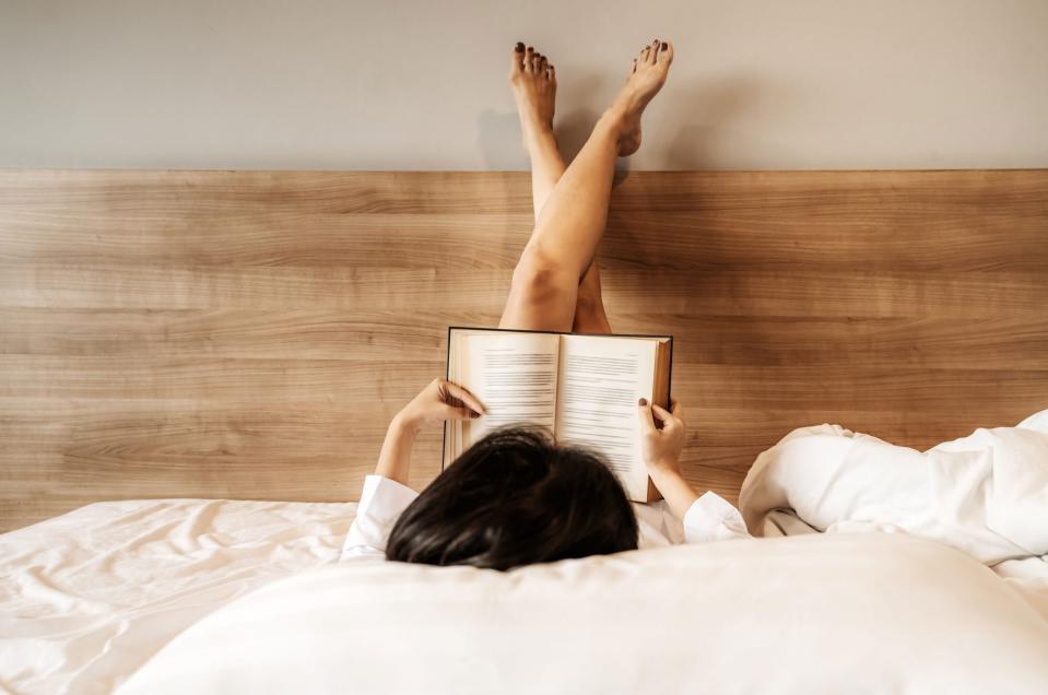 Woman Reading Book on Bed