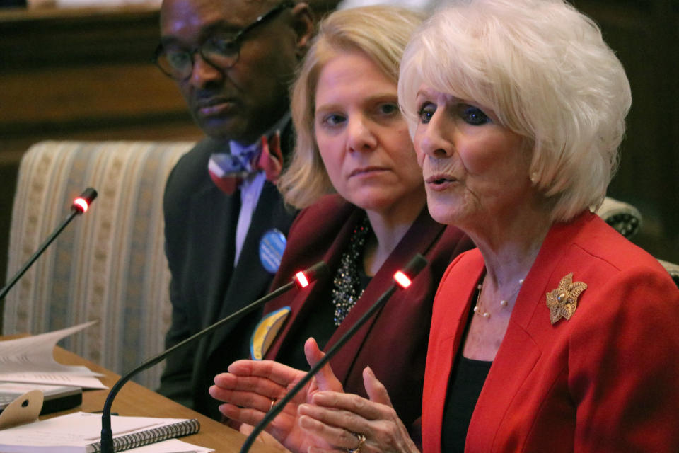 Retired radio talk show host Diane Rehm testifies in favor of a measure in Maryland that would allow the terminally ill to end their lives with the help of a doctor during a hearing on Friday, Feb. 15, 2019, in Annapolis, Md. At center is Kim Callinan, CEO of Compassion & Choices, which supports the bill. The Rev. Charles McNeill, of Unity Baptist Church, left, also testified in favor of the bill. (AP Photo/Brian Witte)