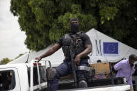 A Haitian policeman waits for the arrival of migrants deported from the US to the Toussaint Louverture International Airport in Port-au-Prince, Haiti, Sunday, Sept. 19, 2021. Thousands of Haitian migrants have been arriving to Del Rio, Texas, to ask for asylum in the U.S., as authorities begin to deported them to back to Haiti which is in a worse shape than when they left. (AP Photo/Rodrigo Abd)